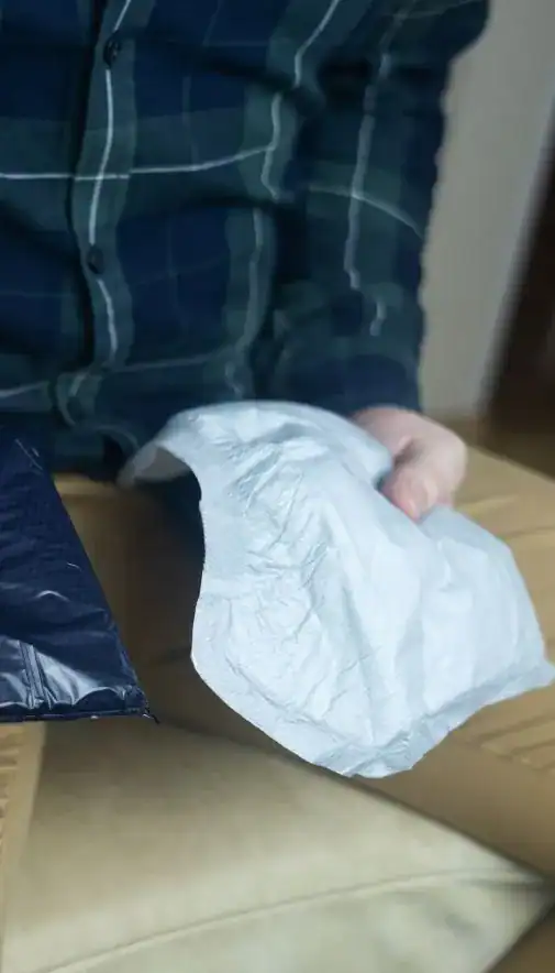 Image of man holding incontinence pads as part of overactive bladder treatment Wigan